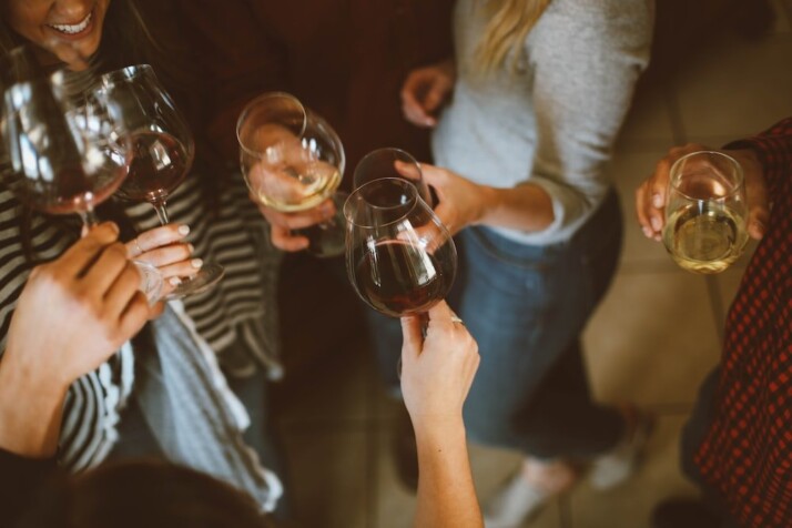 A picture of people toasting wine glasses at a party.