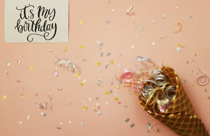 A birthday invitation that features a picture of an ice ream cone filled with confetti.