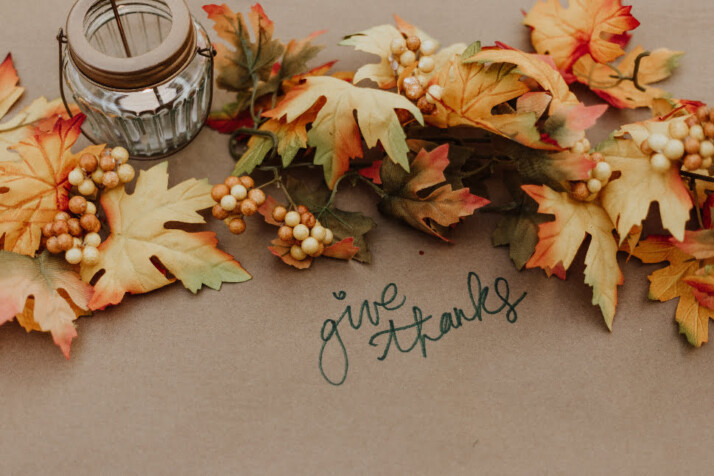 Give Thanks text with Happy Thanksgiving Fall leaves on the ground