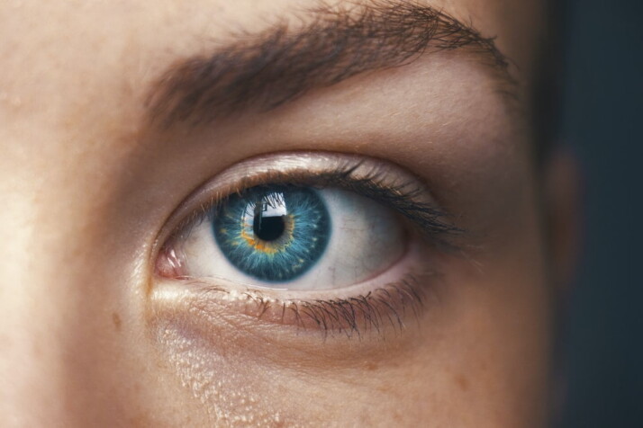 A macro shot of a blue eye that belongs to a woman.