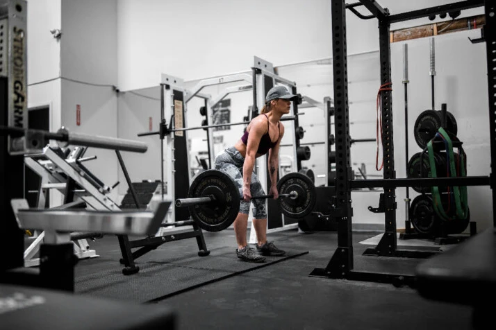 A woman lifting some heavy weights at the gym.