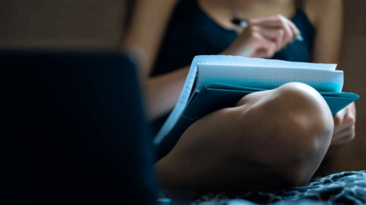 person holding blue and white plastic bottle writing a thesis