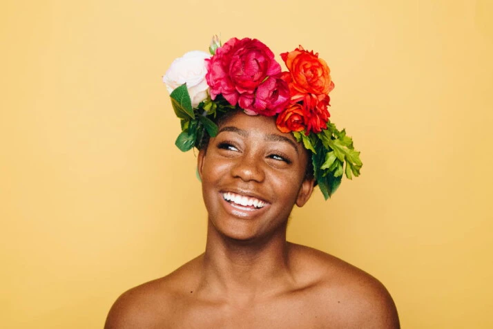 A beautiful woman smiling with flowers in her hair.