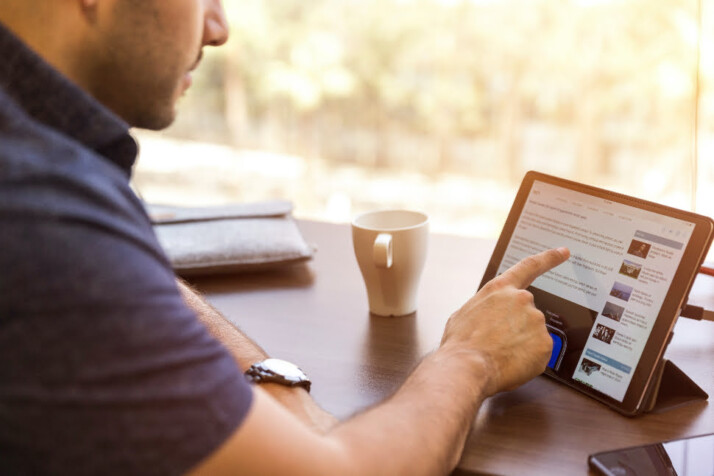 A person scrolling through a website using his iPad.