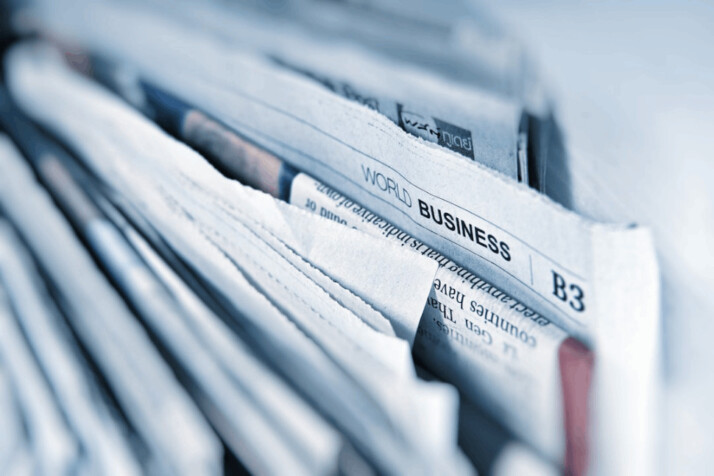 Business newspaper article showing the article piled up with others