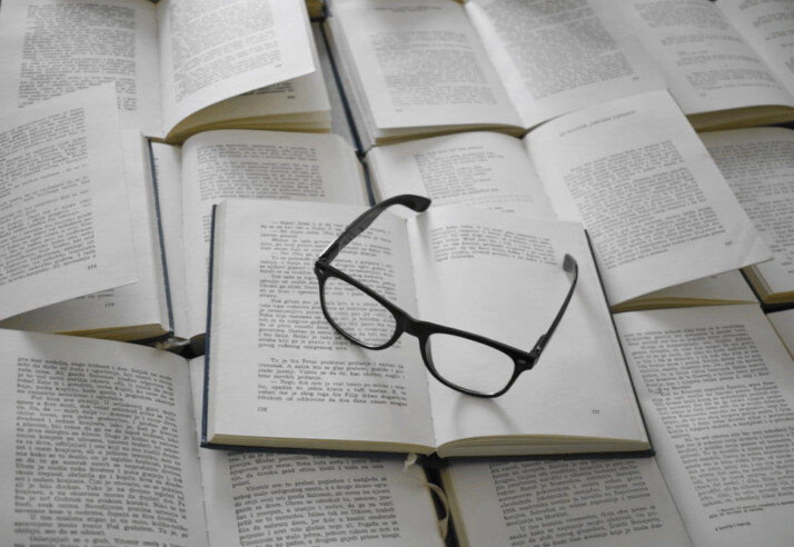 A black framed eyeglasses on a white book page