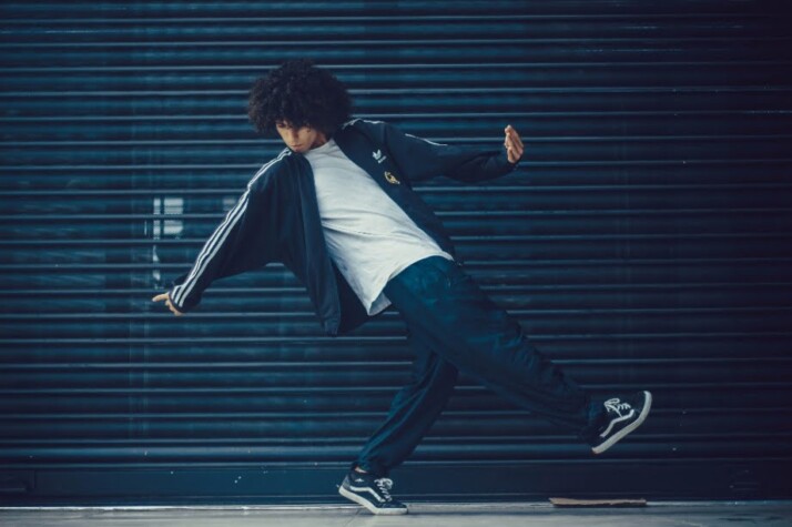 A guy with curly hair showing his dance moves.