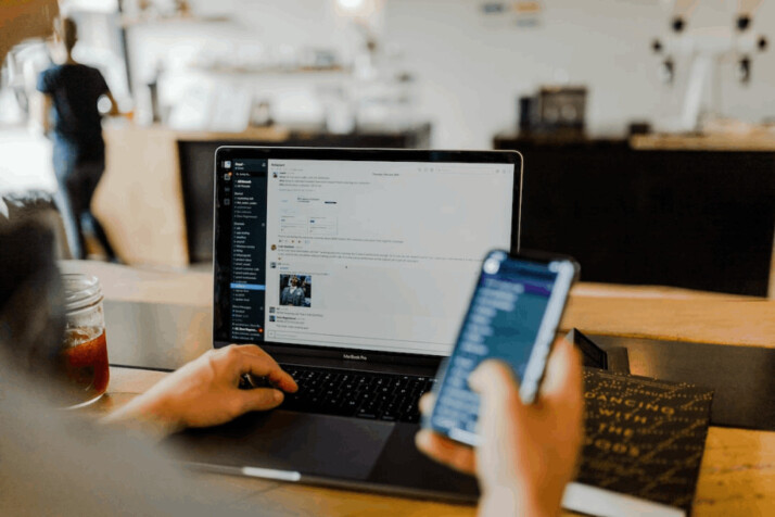 A person using a phone and laptop at the same time