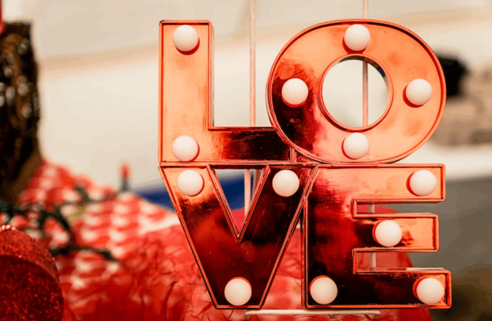 brown and white love lighted signage on red background