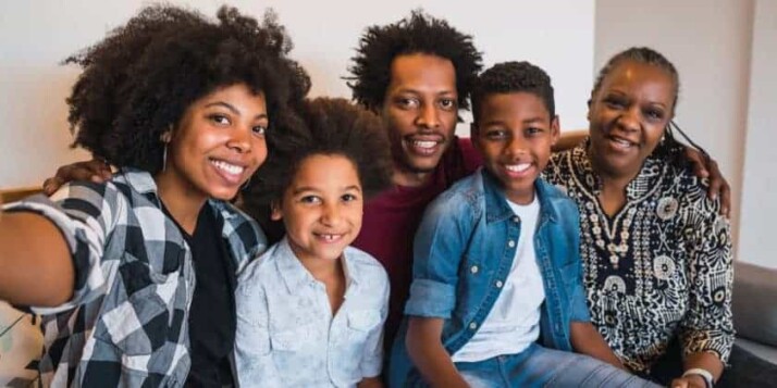black family sitting on a couch and posing for a selfie