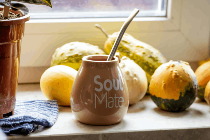 brown ceramic jar with lid beside yellow round fruit