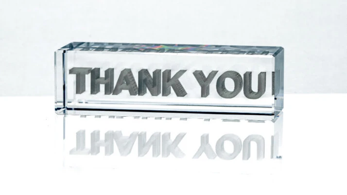 A 3D Thank You signage that is made of glass.