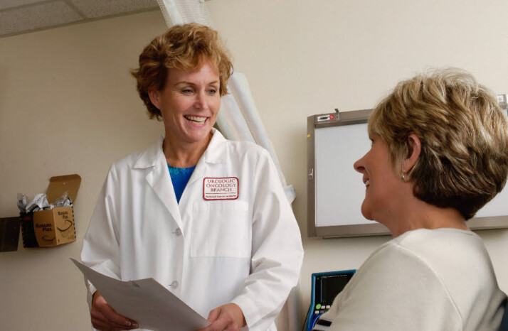 A doctor and patient talking to each other and smiling.
