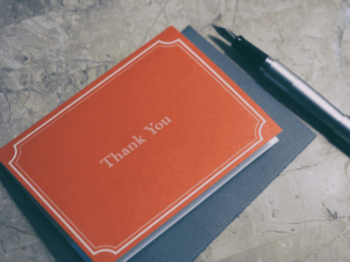 fountain pen next to red Thank You message card