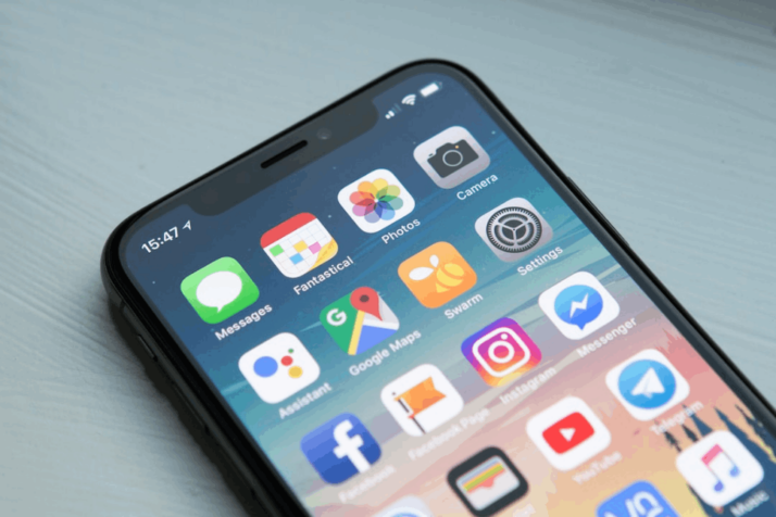 space gray iPhone X showing different icons of various applications