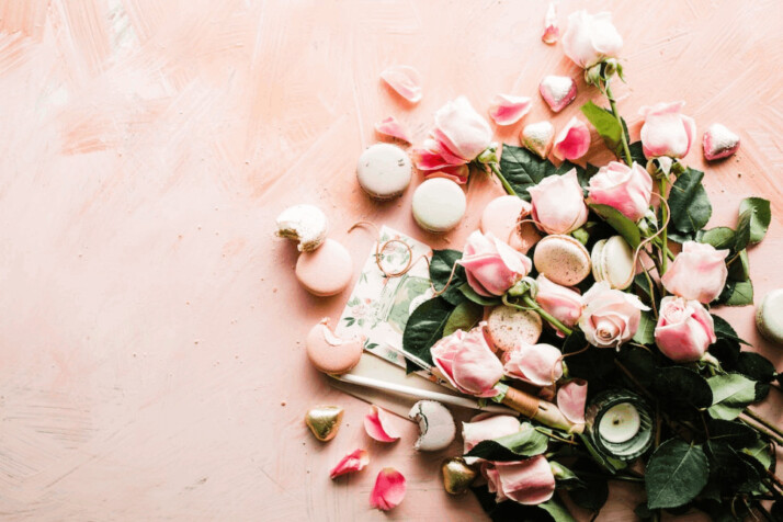 A flat-lay photography of macaroons and pink rose flowers