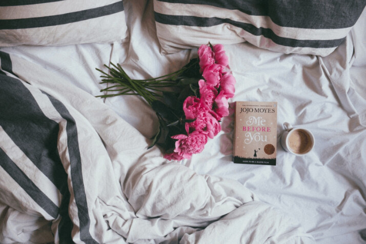 A bouquet of pink flowers on top of bed