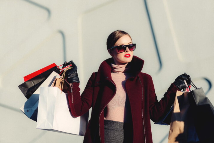 a trendy woman holding a large number of shopping bags.