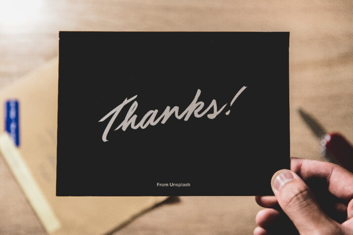 A black thank you note with the word 