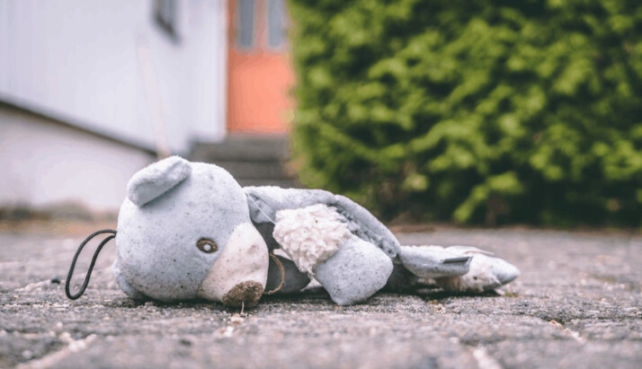 A photo of a bear plush toy on pavement
