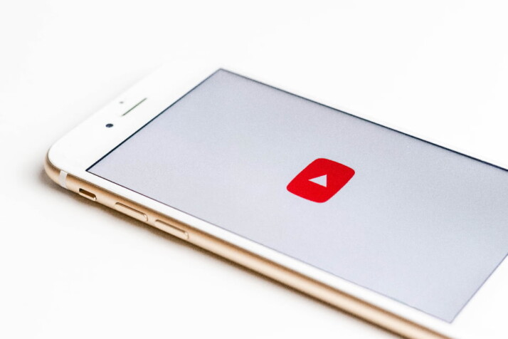 A phone screen displaying the official logo of YouTube.