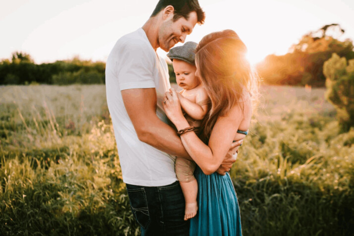 A family photo on green grass during golden hour