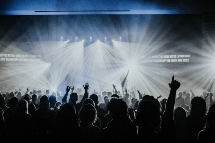 group of people raising hands and having fun at a concert