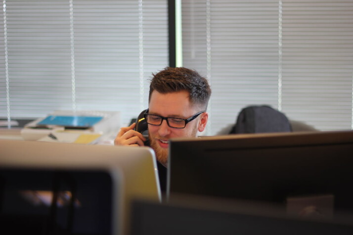 A man talking to a customer over the phone.