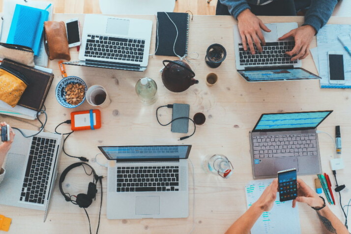 A group of people working on their laptop on one table.