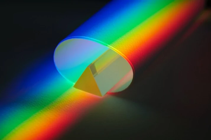 Colorful streaks of light passing through a tube with a triangular prism.