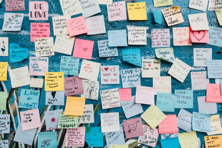An assortment of post it notes on a wall about love