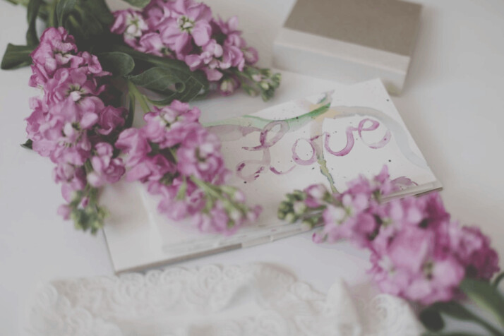 Sticks of pink flowers placed on a white surface