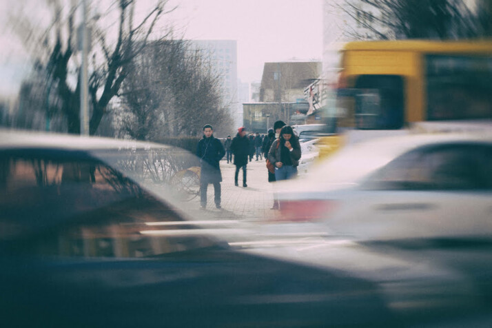 A motion blur photo of a busy street with several cars driving by.