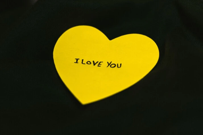 I love You written on yellow cardboard carved into heart shape