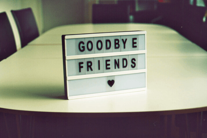 A gray goodbye friends board placed on a table. 