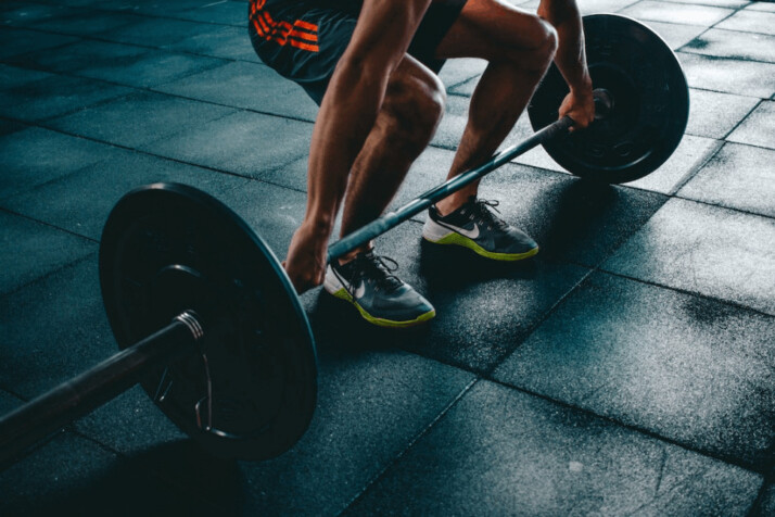 A person in the gym about to lift the barbell