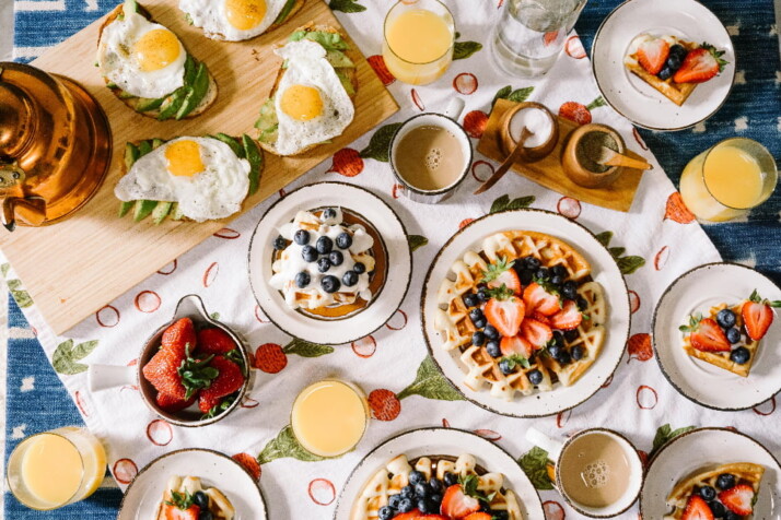 A combination of scrumptious food including pancakes and avocado toasts.