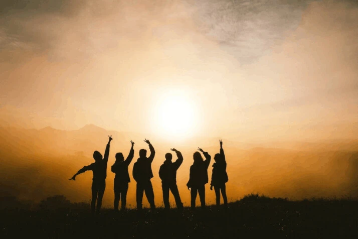 silhouette photo of six people on top of mountain