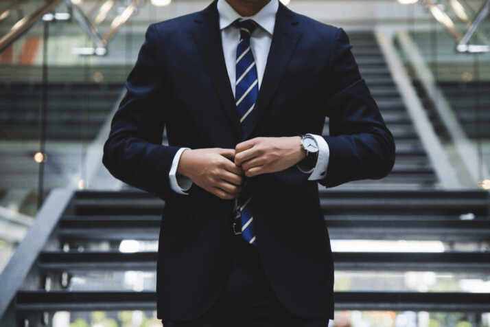 person standing near the stairs wearing a formal suit 