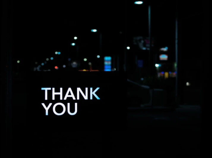 a thank you text on a screen of a car driving down.