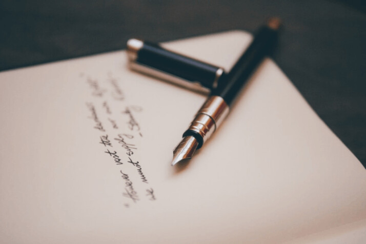 black and silver fountain pen on top of a white page