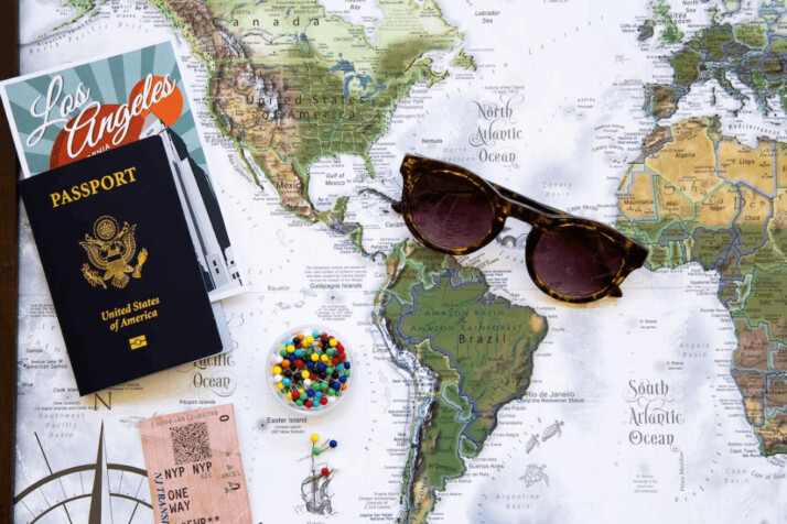 A brown framed sunglasses and American passport on a map