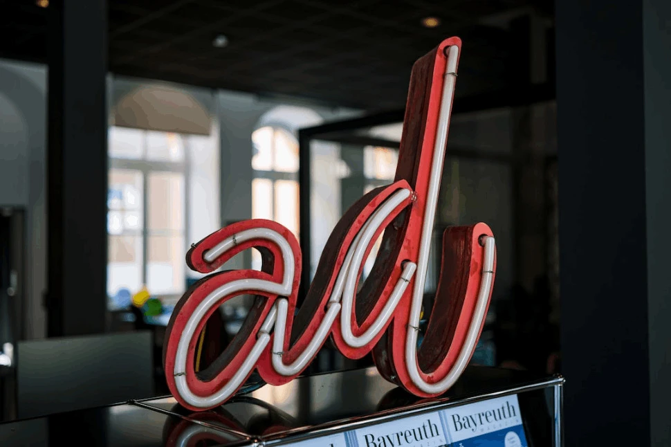 A red and white neon light signage with the word Ad