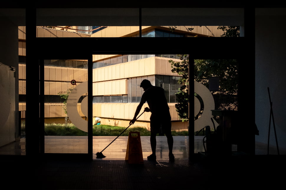 A man cleaning the floor at an entrance door