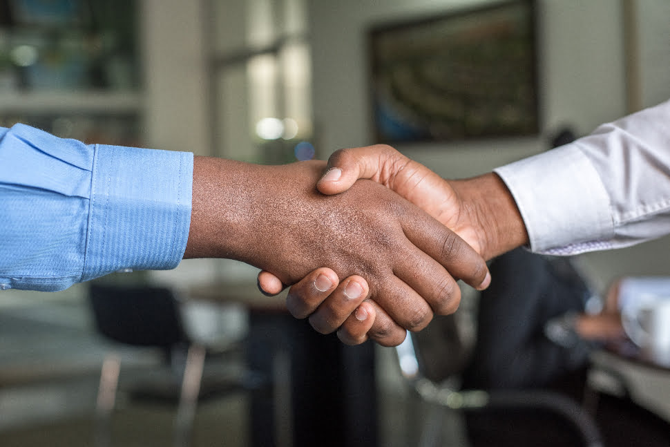 Two people doing a handshake to seal a business deal.