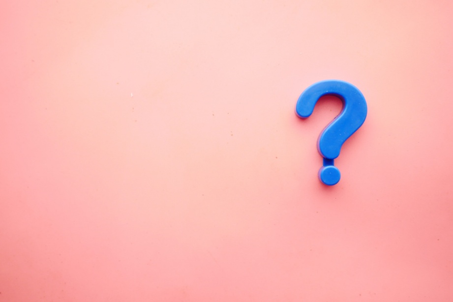 A blue question mark pictured against a pink background.