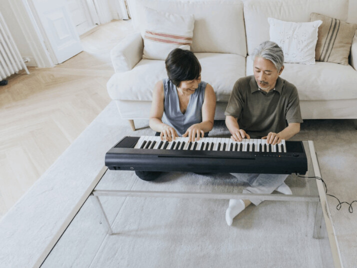 A old age couple playing Piano
