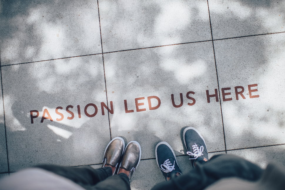 Passion Led Us Here text in brown written on a tile floor. 