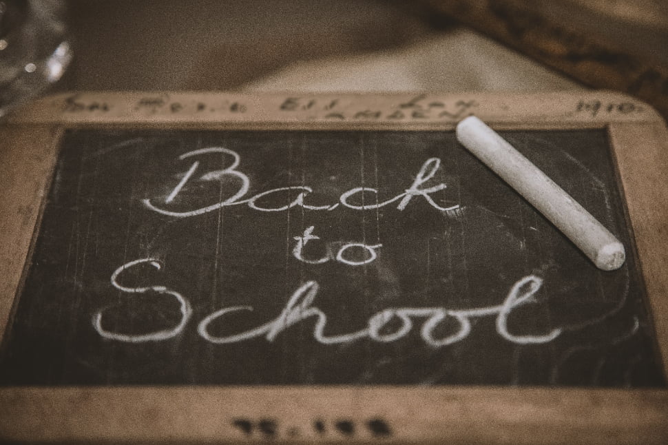 a blackboard that reads back to school next to white chalk