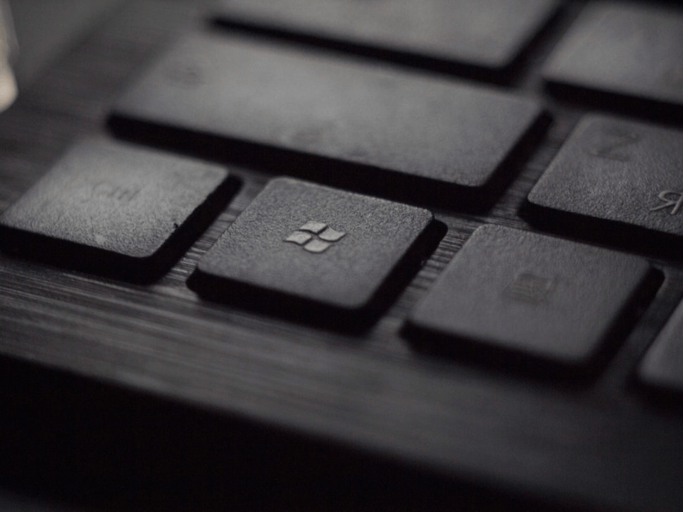 black laptop computer keyboard in closeup photo showing microsoft logo